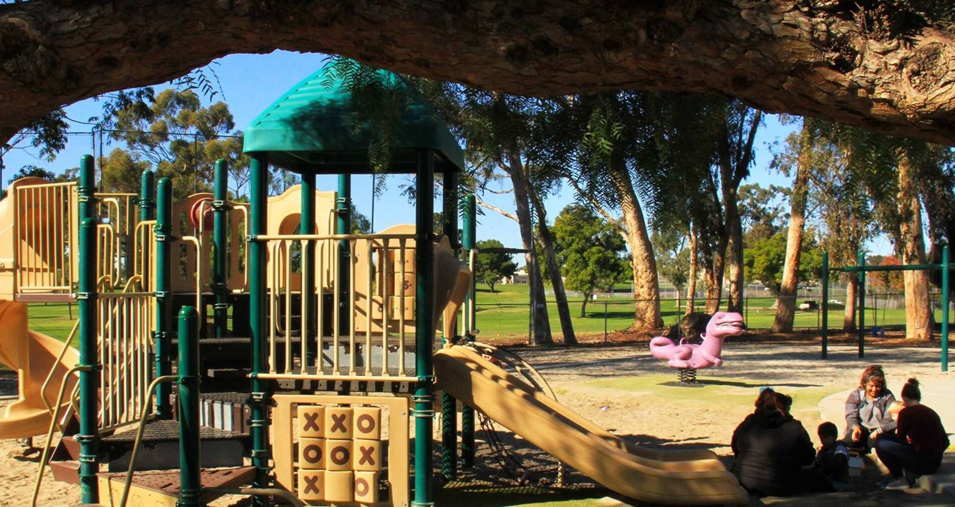 children's playground with a family playing on it